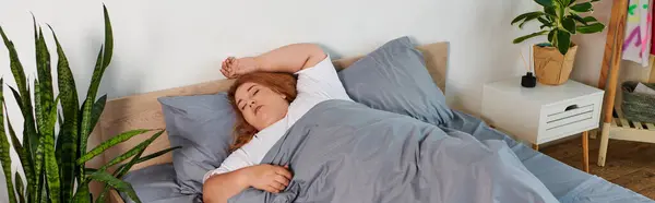 Красивая женщина plus size раскинулась в своей уютной спальне в окружении зелени. — стоковое фото