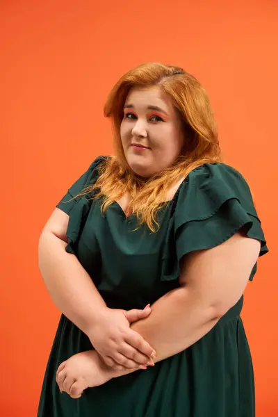 The confident plus size woman rocks her stylish outfit against an orange wall. — Stock Photo