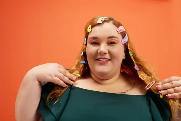 A plus size woman shows her unique style with colorful hair clips and a bright backdrop. — Stock Photo