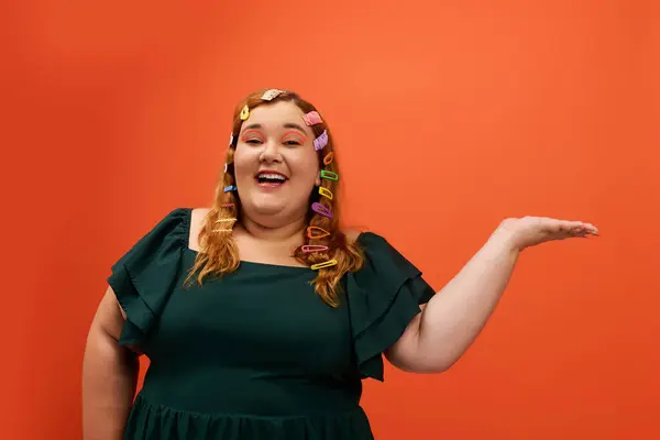 A cheerful plus size woman shows her playful spirit with colorful clips against a bold backdrop. — Stock Photo