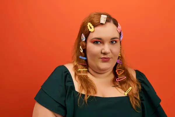A beautiful plus size woman showcases her unique style with colorful hair clips and bold makeup. — Stock Photo