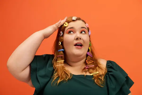 A joyful plus size woman playfully adjusts her hair with colorful clips, radiating confidence. — Stock Photo