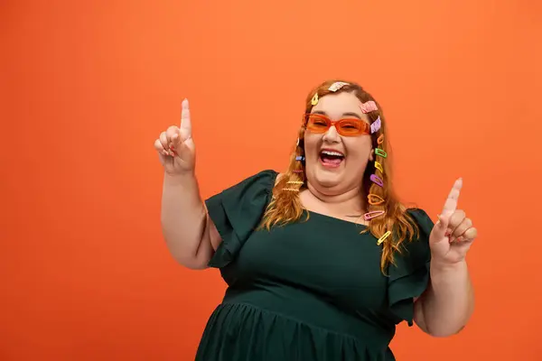 A joyful plus size woman with colorful clips expresses herself against a vibrant backdrop. — Stock Photo