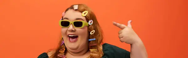 A cheerful plus size woman showcases her colorful hair accessories while smiling broadly. — Stock Photo