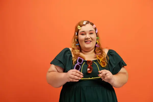 A joyful plus size woman with colorful accessories radiates confidence in a bright setting. — Stock Photo