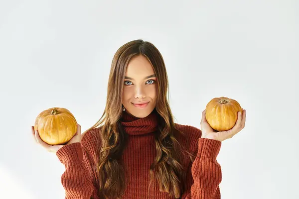 A young woman in a Halloween costume smiles with two pumpkins, celebrating the season. — Stock Photo