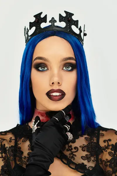 This young woman showcases a dramatic Halloween look featuring bold makeup and a unique crown. — Stock Photo