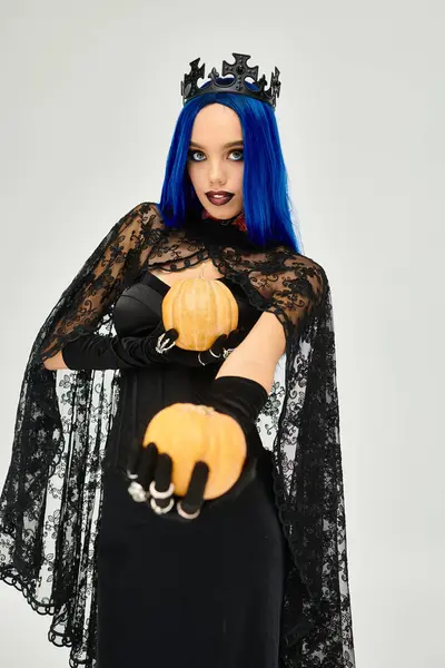In einem atemberaubenden Halloween-Kostüm präsentiert eine junge Frau ihren lebendigen Stil mit Kürbissen. — Stockfoto