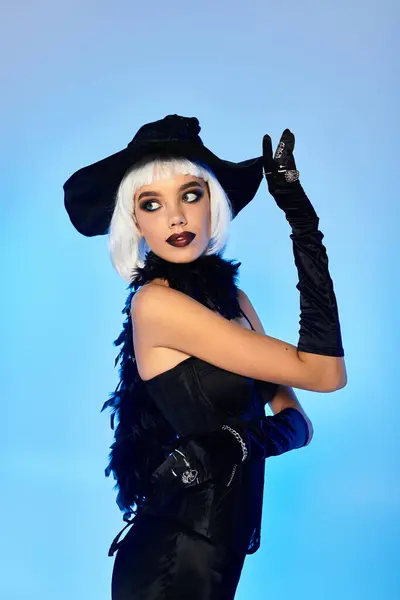A beautiful young woman showcases her enchanting Halloween witch costume with flair and style. — Stock Photo