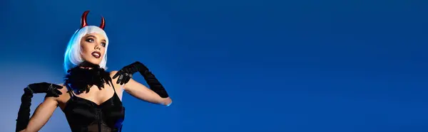 The young woman showcases her stunning Halloween costume with playful confidence and flair. — Stock Photo