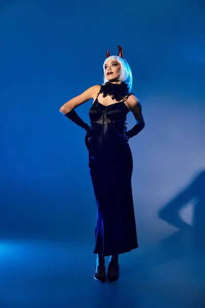 Habillée d'une élégante tenue d'Halloween, une belle femme respire la confiance sous un éclairage bleu. — Photo de stock