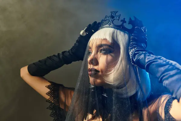 A stylish young woman wows onlookers in a unique Halloween costume with a crown and veil. — Stock Photo