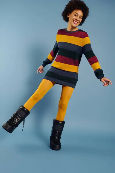 Uma jovem mulher mostra sua felicidade enquanto golpeia uma pose brincalhona na moda de inverno colorida. — Fotografia de Stock