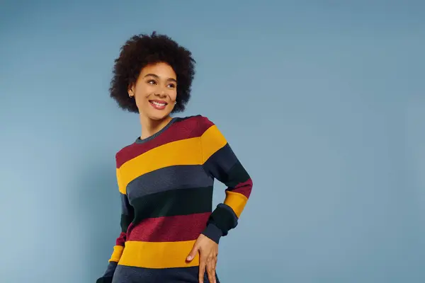 A young woman expresses joy and confidence, radiating emotion in a vibrant, patterned sweater. — Stock Photo