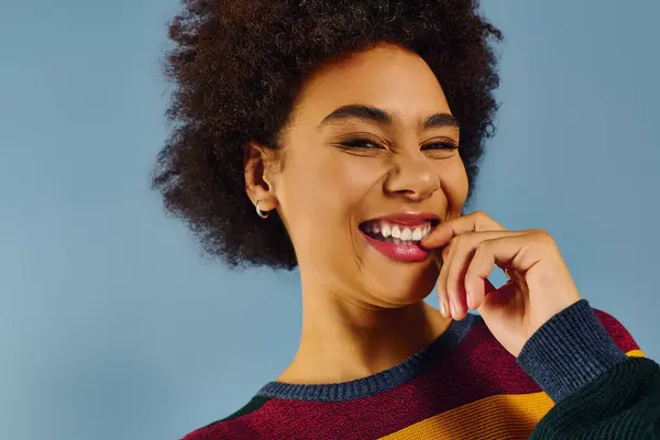 A young woman radiates happiness while playfully biting her finger in a cheerful setting. — Stock Photo