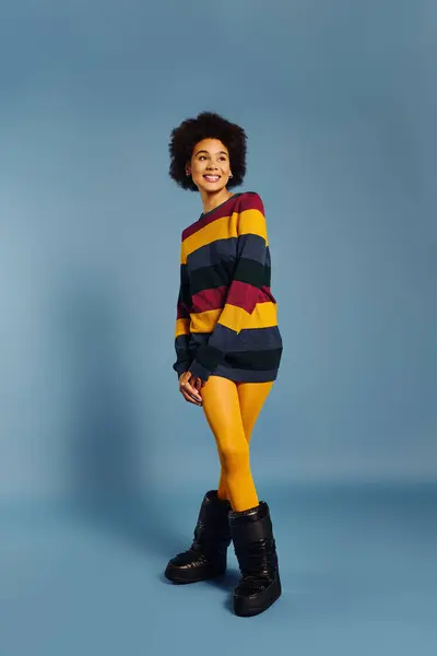 The young woman displays a bright smile, embracing her vibrant style against a soft backdrop. — Stock Photo