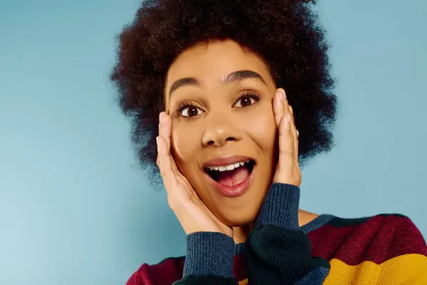 A young woman with curly hair expresses excitement and happiness, brightening the surroundings. — Stock Photo