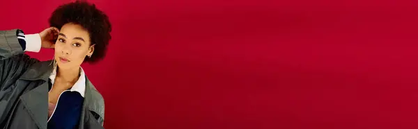 A young woman expresses deep emotions while contemplating against a striking red backdrop. — Stock Photo