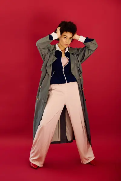 A young woman expresses her emotions in striking poses, dressed fashionably in a bold setting. — Stock Photo