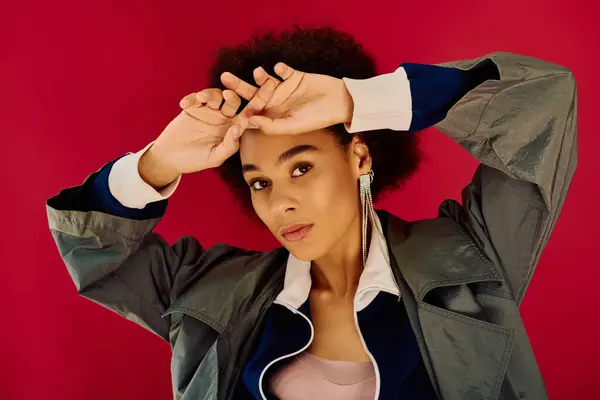 A young woman showcases deep emotion while striking a dynamic pose against a vivid pink background. — Stock Photo