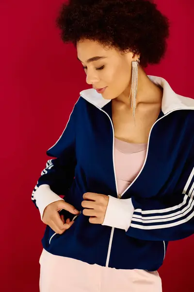 A young woman expresses deep emotion while adjusting her jacket in a bright setting. — Stock Photo