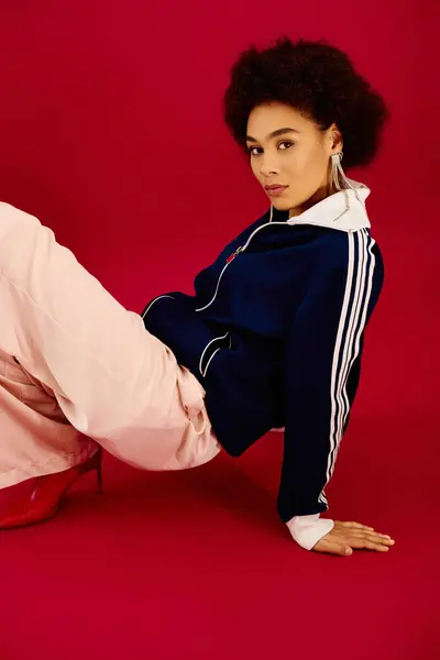 A young woman with an emotional look sits stylishly, flaunting her unique fashion in a bold setting. — Stock Photo