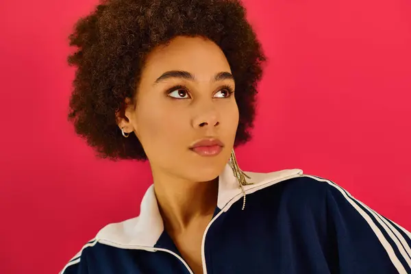 A young woman expresses deep emotion, showcasing her curls against a striking pink backdrop. — Stock Photo