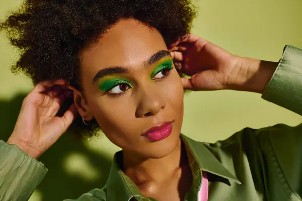 Eine junge Frau zeigt farbenfrohes Make-up, das tiefe Emotionen in einer eindrucksvollen Atmosphäre widerspiegelt. — Stockfoto