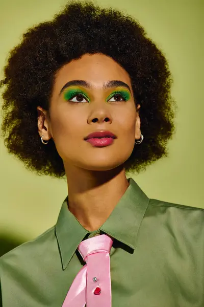 With bright green eyeshadow and a playful tie, the young woman exudes emotion in her pose. — Stock Photo