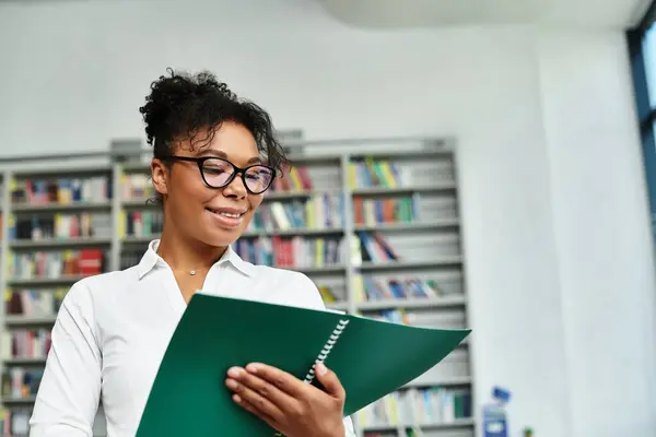 An inspiring african american teacher engages with students while reviewing materials in a library. — Stock Photo