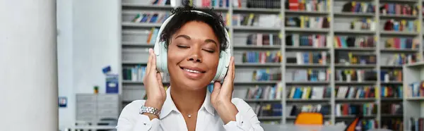 An inspiring African American teacher listens to music in her lively educational workspace. — Stock Photo