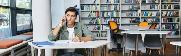 A committed student deeply concentrated while studying at a contemporary library. — Stock Photo