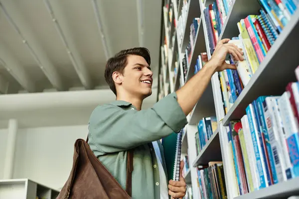 In einer lebendigen Bibliothek erkundet ein fokussierter Student Bücherregale, motiviert, mehr zu erfahren. — Stockfoto