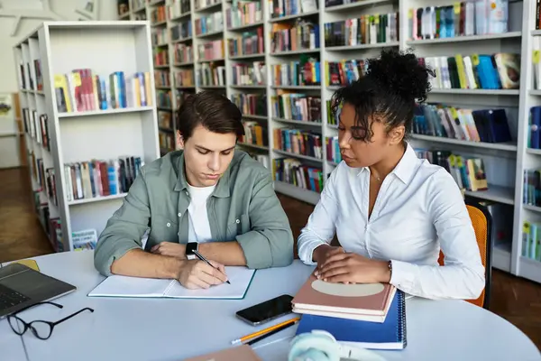 A patient educator assists her focused student with engaging lessons in the library. — Stock Photo