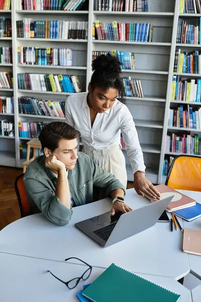 Eine Lehrerin unterstützt ihre junge Schülerin mit einem Laptop beim gemeinsamen Lernen. — Stockfoto