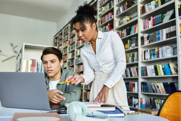 A teacher provides valuable insights while her student engages with a laptop and notes. — Stock Photo