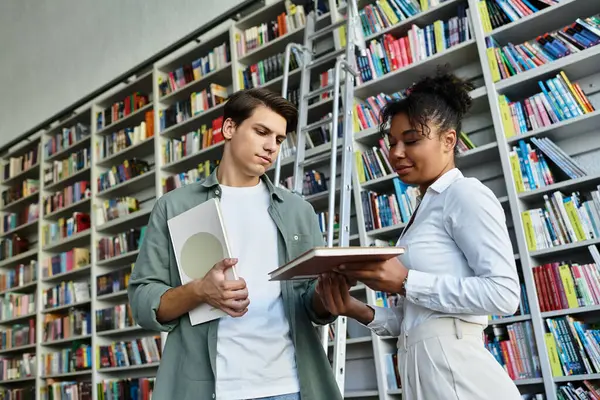 A dedicated teacher shares insights with her young student in a colorful library filled with books. — Stock Photo
