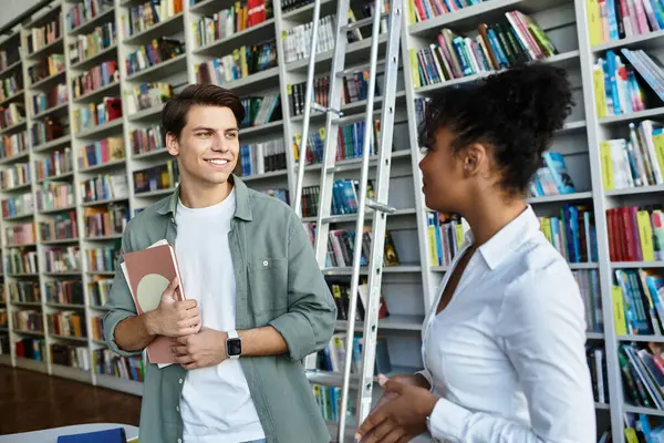 A passionate educator engages with her attentive student while surrounded by shelves of books. — Stock Photo