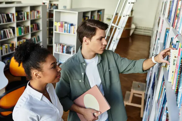 A teacher assists her eager student as they explore a vibrant library filled with books. — Stock Photo