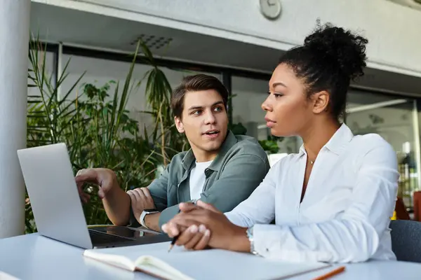 Étudiant et son professeur se concentrent sur leurs ordinateurs portables tout en partageant leurs idées dans une bibliothèque dynamique. — Photo de stock