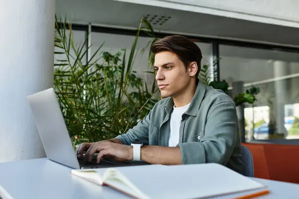 A student works diligently on a laptop, immersed in coursework amid library tranquility. — Stock Photo