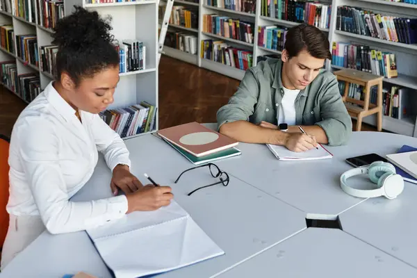 A teacher provides valuable instruction to a student in a quiet library setting. — Stock Photo