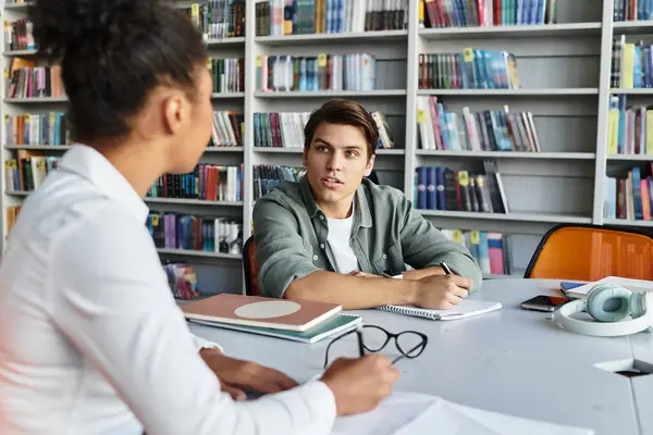 A young educator passionately instructs her student in a colorful library environment. — Stock Photo