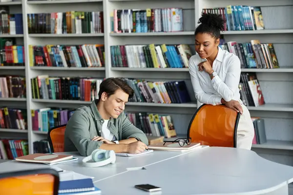 A passionate teacher supports her student with focused learning in a lively library space. — Stock Photo