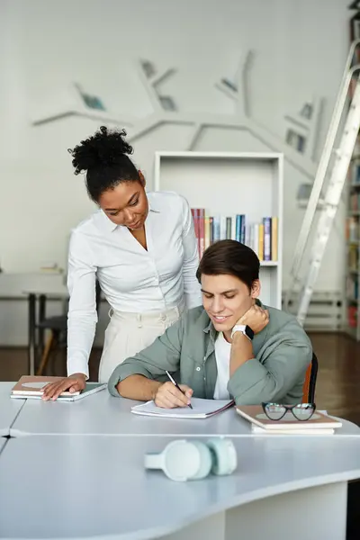 A professional educator assists her student with focused attention in a modern classroom. — Stock Photo