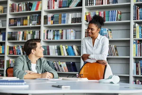 A dedicated teacher engages her student in a warm library, encouraging learning and growth. — Stock Photo