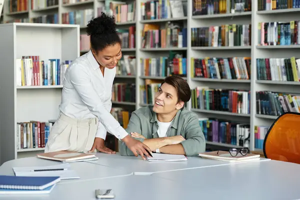A dedicated teacher guides her student in understanding lessons while surrounded by books. — Stock Photo