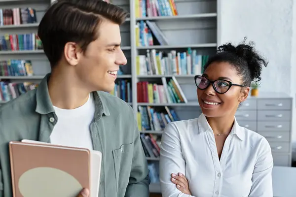 In a vibrant library, a dedicated teacher engages her curious student, sparking learning. — Stock Photo