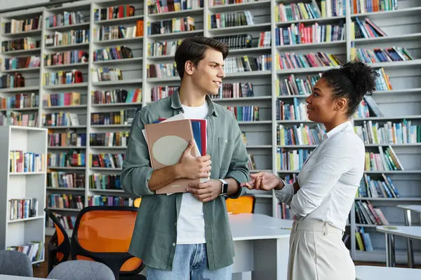 In a vibrant library, a teacher interacts with her attentive student, fostering learning and growth. — Stock Photo