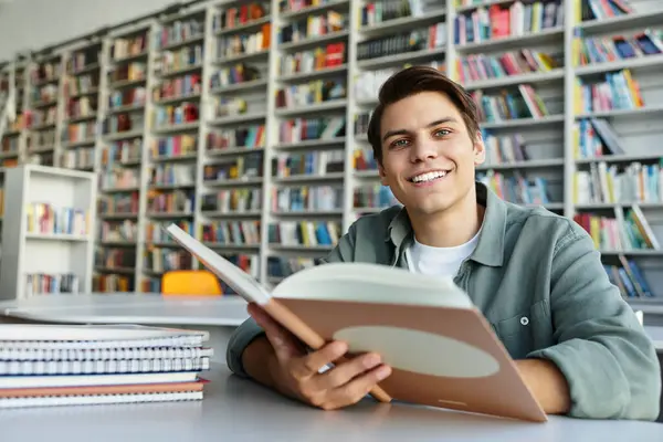 Zufriedener, gutaussehender Schüler in lässiger Kleidung in der Schule, der hart lernt. — Stockfoto